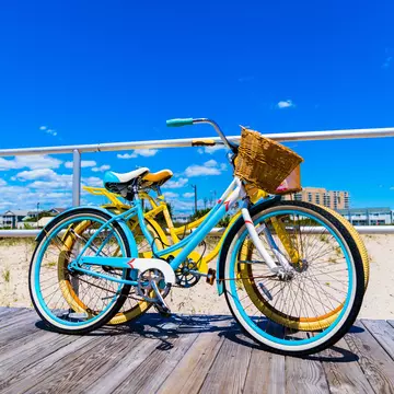 Vintage Style Bicycles Teal and Yellow on Ocean City New Jersey Boardwalk with Beautiful Blue Sky with some Clouds Vivid Colors  License Type: media  Download Time: 2021-08-27T15:06:18.000Z  User: AMccarthy_lonelyplanet  Is Editorial: No  purchase_order: