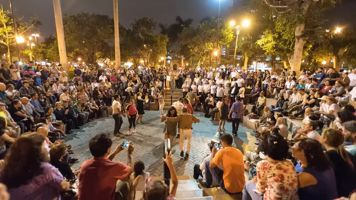 People dancing at night in a square in Lima, Peru.
