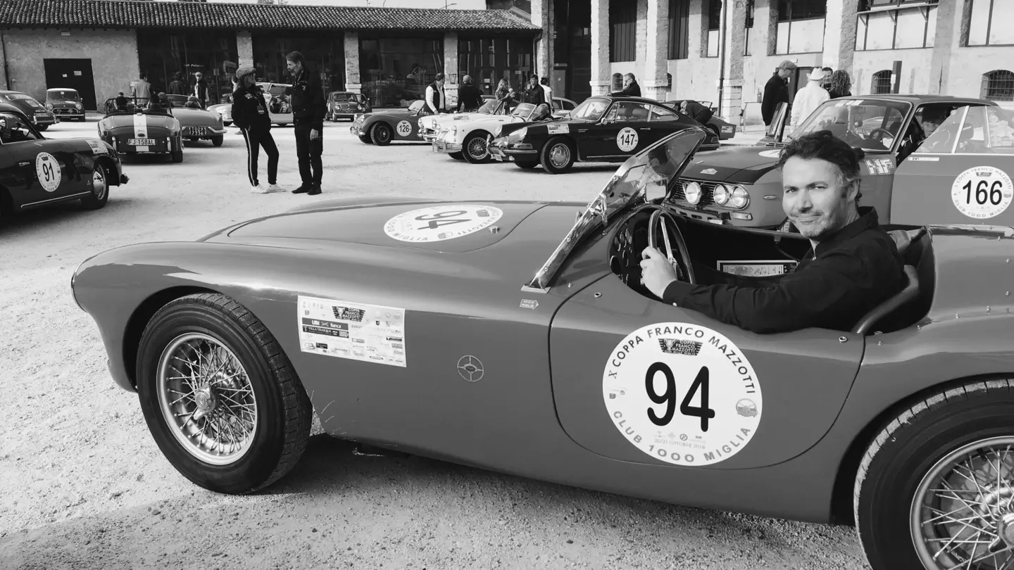 Black-and-white shot of the writer, Peter, sat in a classic sports car