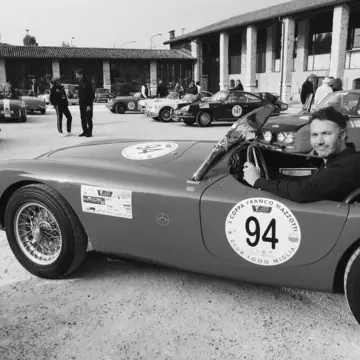 Black-and-white shot of the writer, Peter, sat in a classic sports car