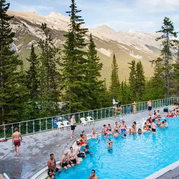 BANFF, CANADA - JULY 2, 2014 : Summer visitors soaking in the historic hot, mineral-rich water of Banff Upper Hot Springs with Rundle and Cascade Mountains in the background., License Type: media, Download Time: 2025-11-27T16:55:53.000Z, User: Eointloughney87, Editorial: true, purchase_order: 56530 - Guidebooks, job: Global Publishing-WIP, client: BCO11, other: Eoin T Loughney