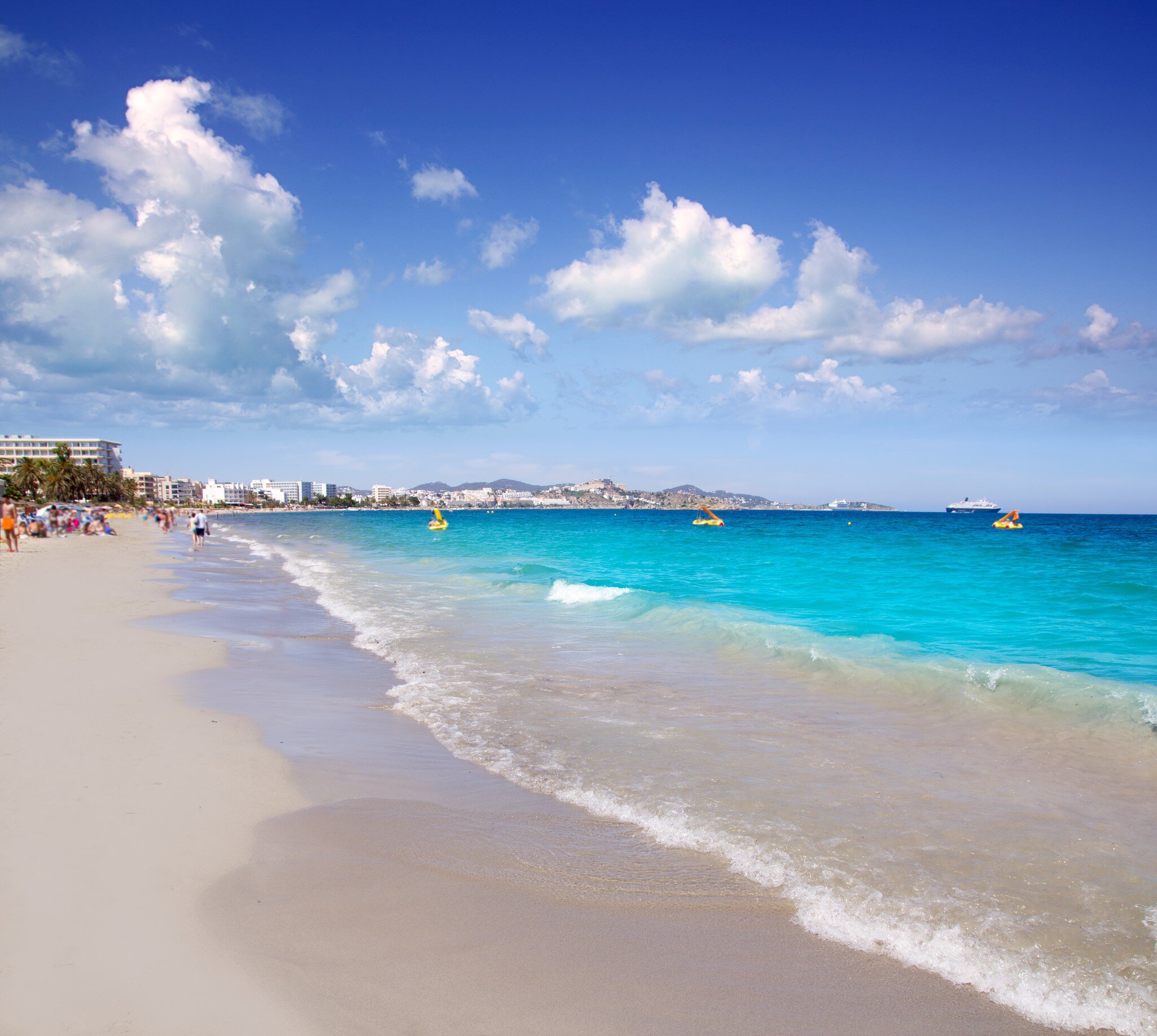 View of waves lapping onto the shore at Platja d'en Bossa on the island of Ibiza in Spain.