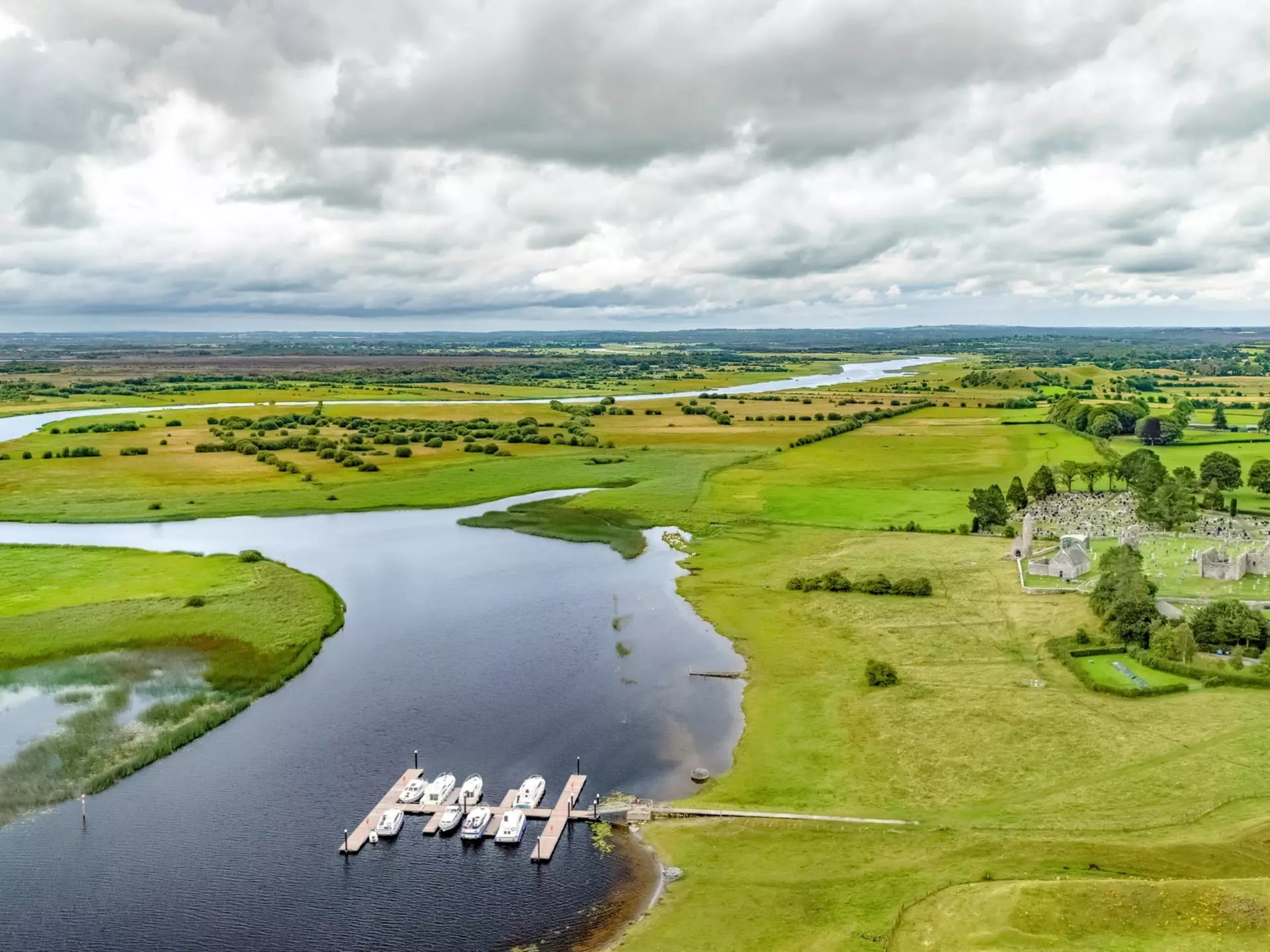 Aerial drone view of Shannon river and countryside rural irish landscape, Clonmacnoise monastery ruins and small marina with vacation river boats, county Offaly, Ireland, License Type: media, Download Time: 2025-12-04T16:42:27.000Z, User: nic.dhoedt_lonelyplanet, Editorial: false, purchase_order: 56530 - Guidebooks, job: Global Publishing WIP , client: Lonely Planet Ireland 17, other: Nicolas D'Hoedt