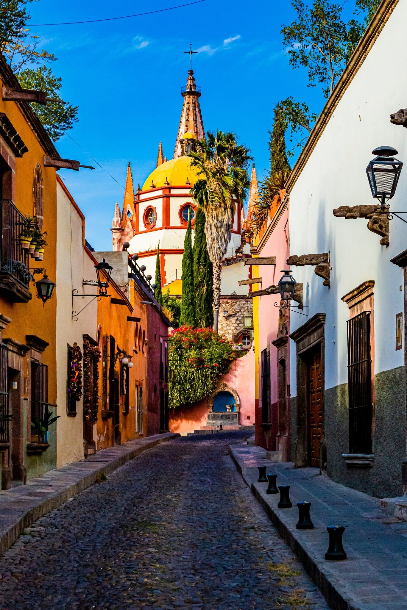 View down Calle Aldama, a famous cobblestone street in San Miguel de Allende, Mexico, with the view of the Parroquia de San Miguel Arcángel in the background.