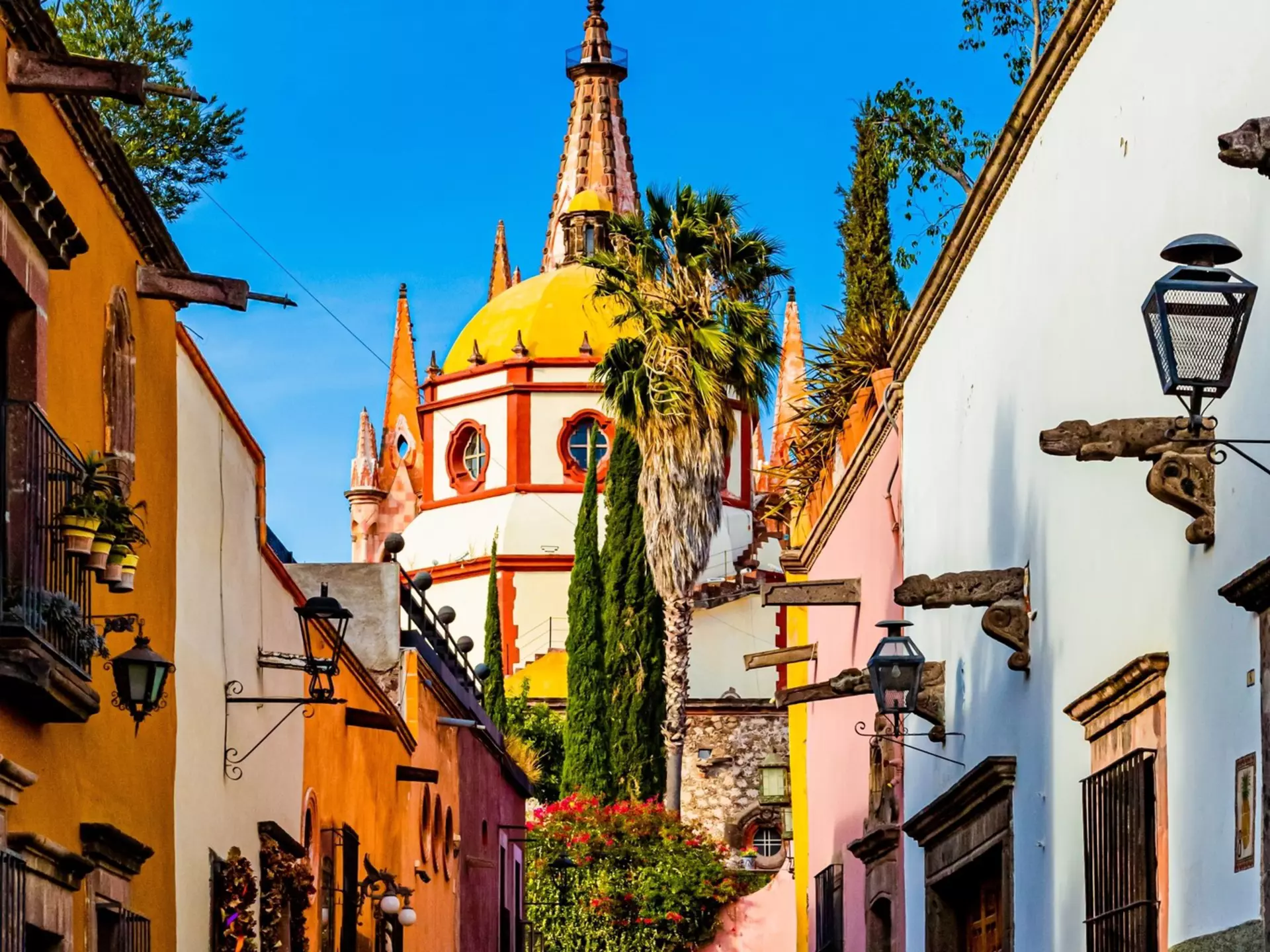 View down Calle Aldama, a famous cobblestone street in San Miguel de Allende, Mexico, with the view of the Parroquia de San Miguel Arcángel in the background.