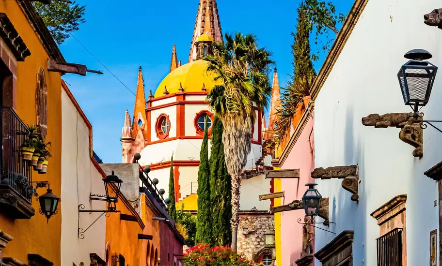 View down Calle Aldama, a famous cobblestone street in San Miguel de Allende, Mexico, with the view of the Parroquia de San Miguel Arcángel in the background.