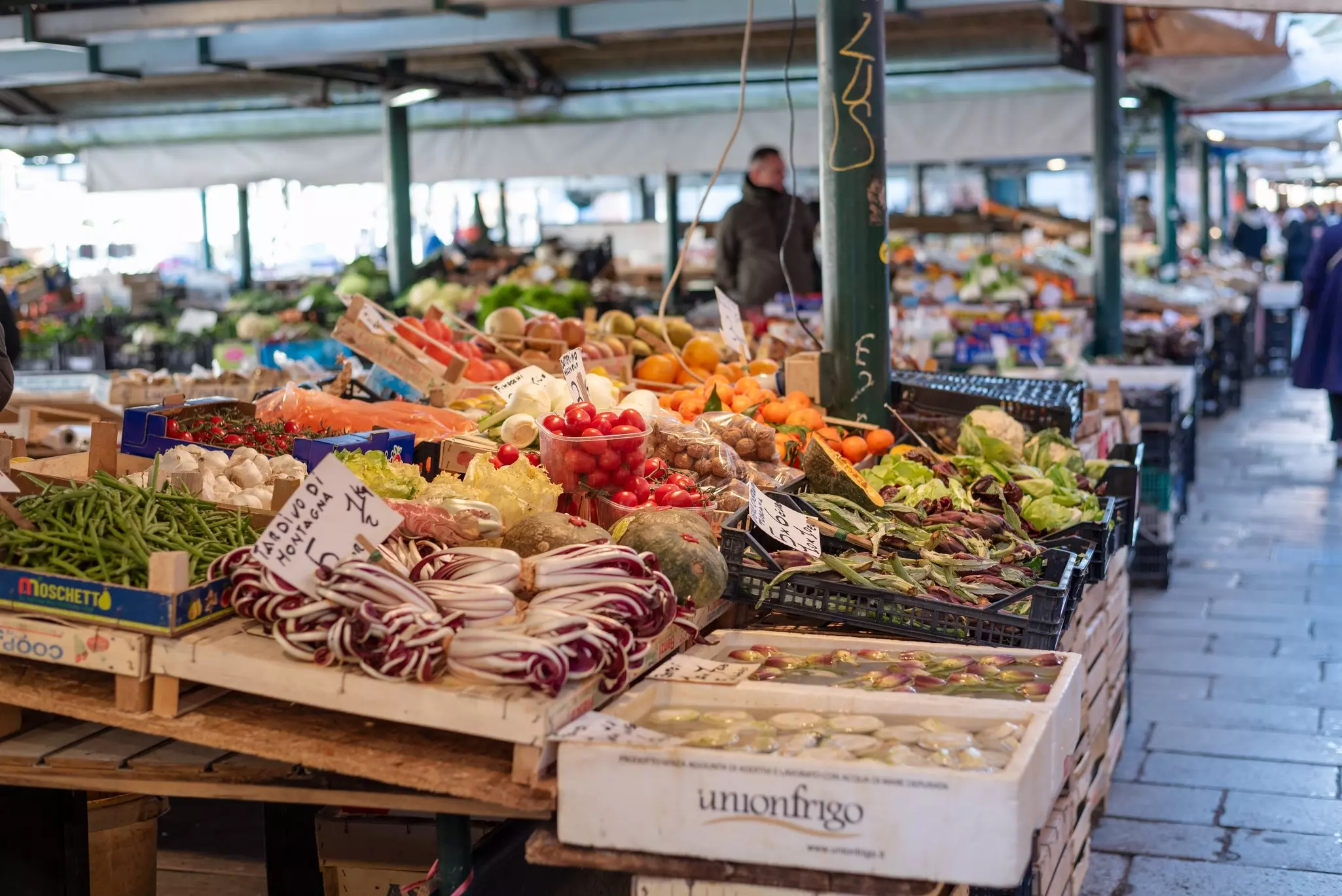 Venice, Italy - December 11th 2024: A vibrant display of fresh fruits and vegetables at Rialto Market, Venice, featuring tomatoes, radicchio, beans, and citrus fruits neatly arranged in crates., License Type: media, Download Time: 2025-07-01T19:12:50.000Z, User: lonelyplanetmedia, Editorial: true, purchase_order: 65050 - Digital Destinations and Articles, job: Global Publishing WIP, client: App, other: Pia Peterson Haggarty