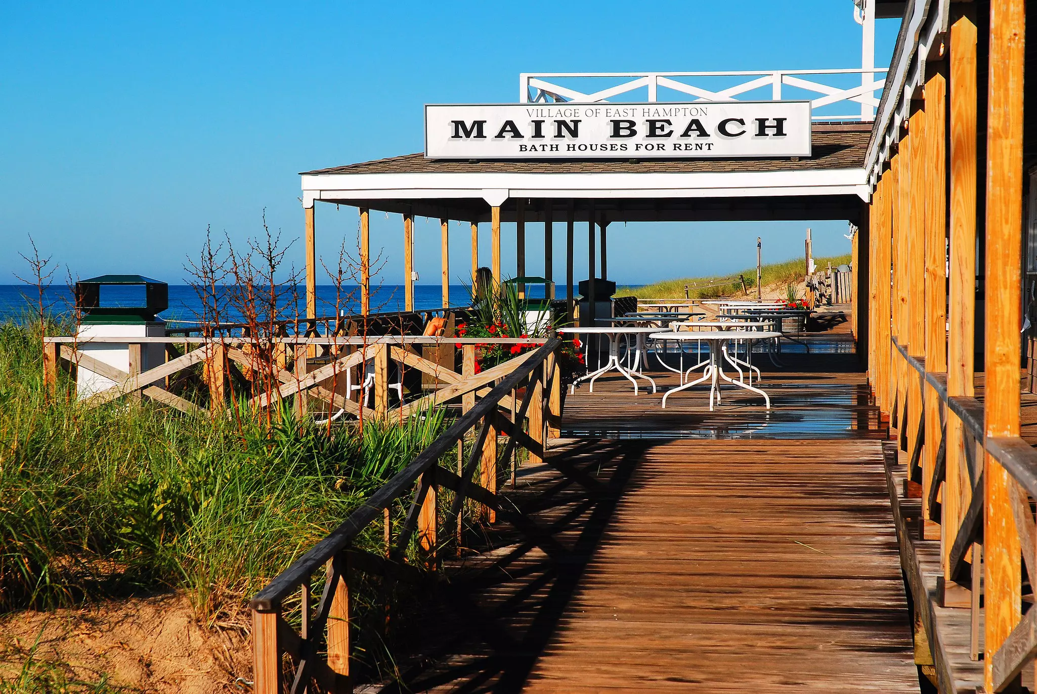 Brown decking with a covered porch and a sign that says Main Beach