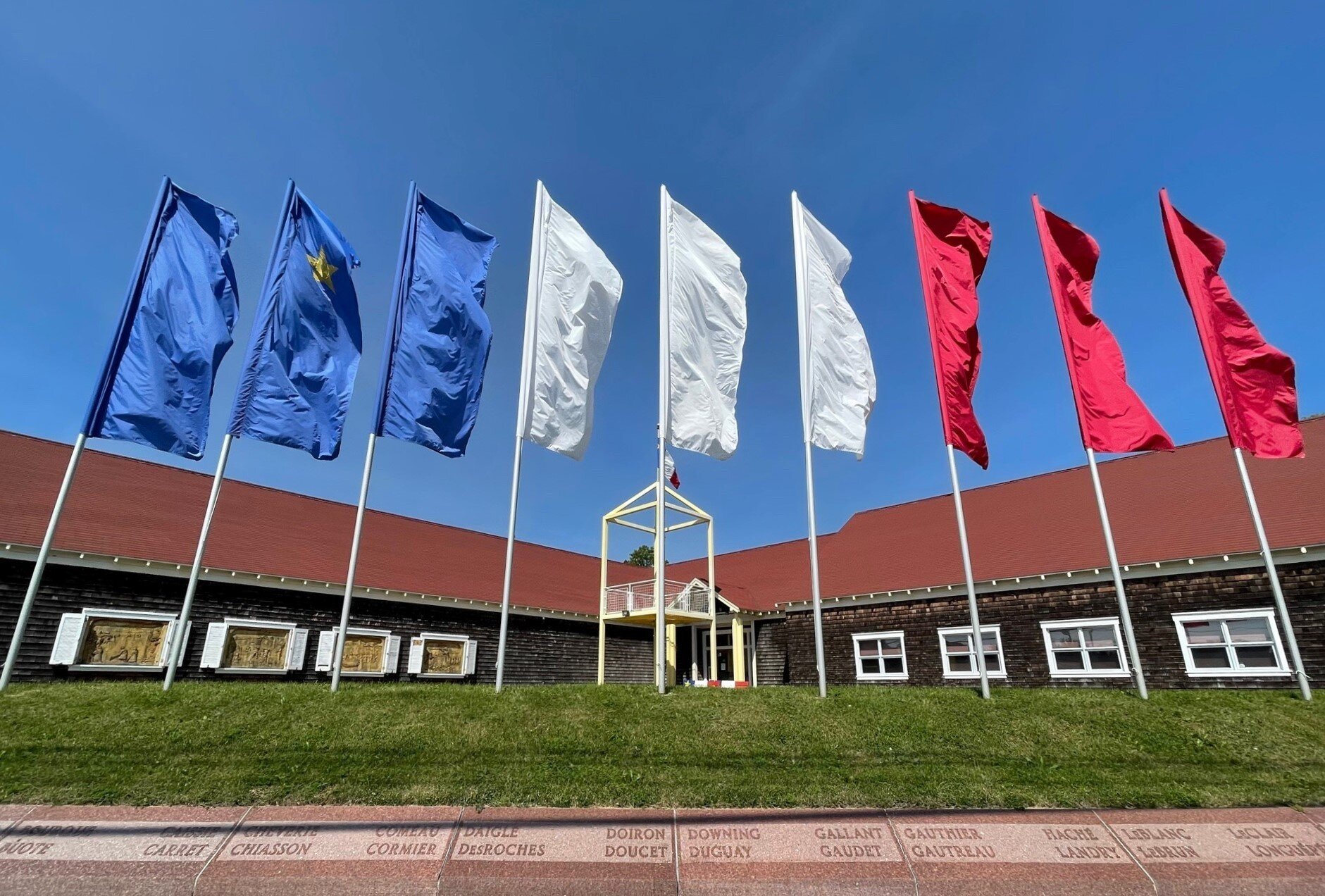 Colorful flags fly in the wind outside the Acadian Museum in Prince Edward Island, Canada.
