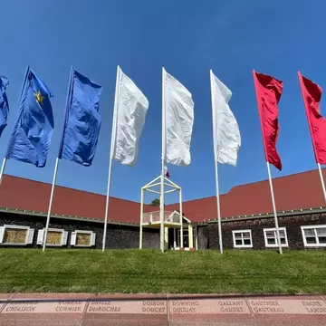 Colorful flags fly in the wind outside the Acadian Museum in Prince Edward Island, Canada.