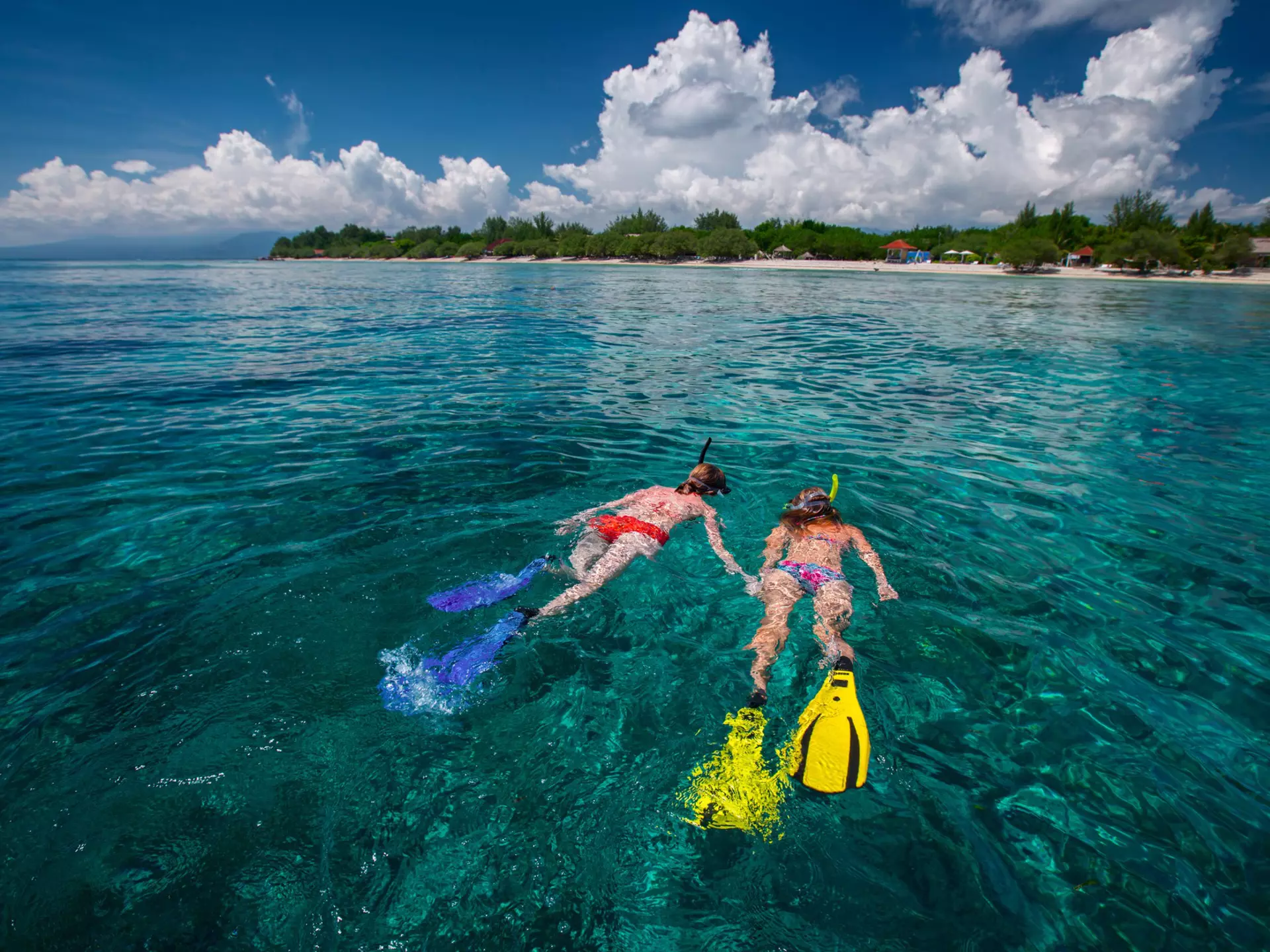 Two ladies snorkeling in a tropical, clear sea near Gili Trawangan island, Indonesia