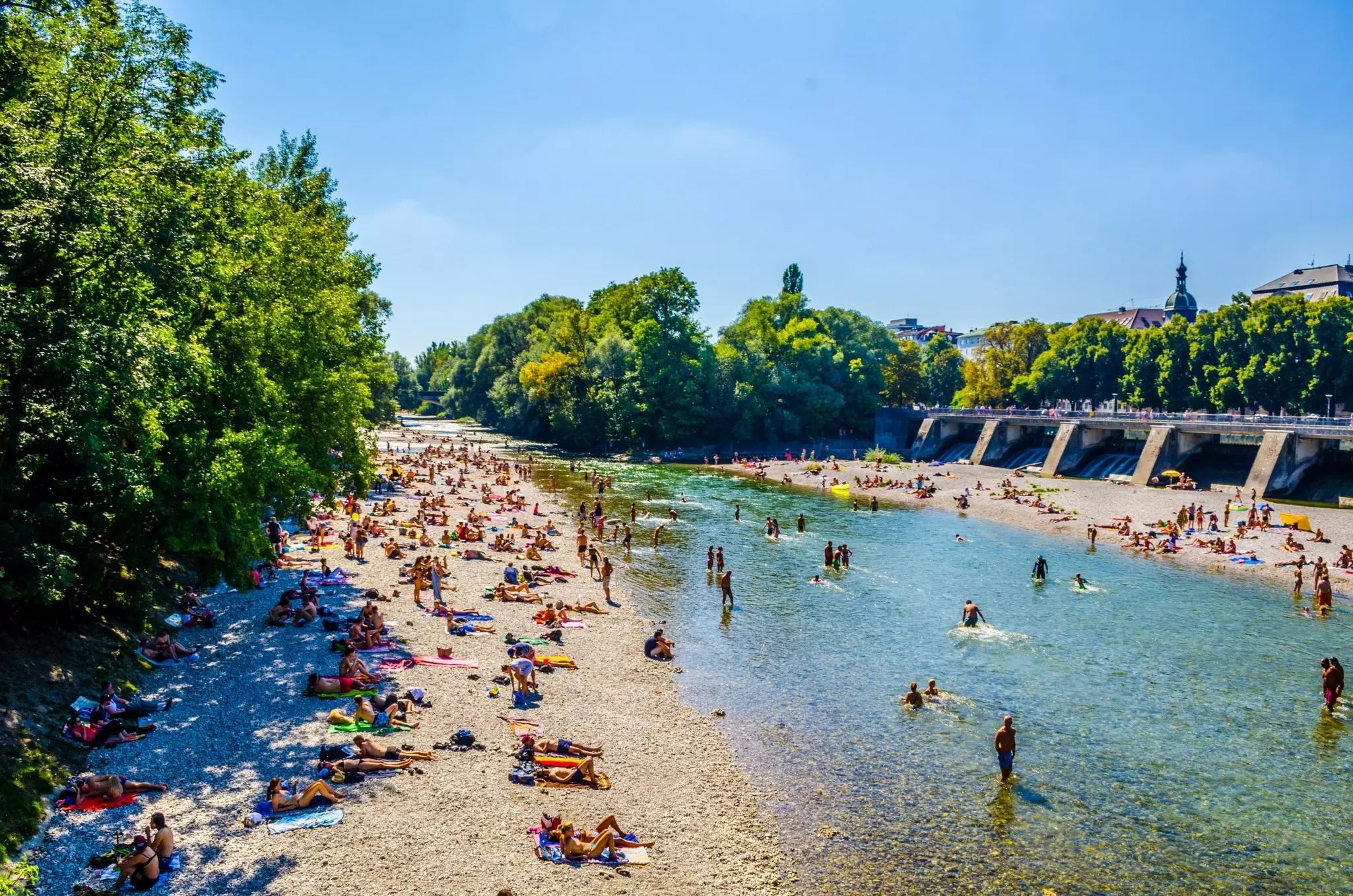 People enjoy sunny hot weather on the river banks of Isar river in bavarian city Munich. The river becomes a giant beach during hot days.,