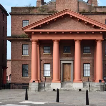 Red-brick Dock Traffic Office with a pink-columned portico and wooden doors at Royal Albert Dock, Liverpool