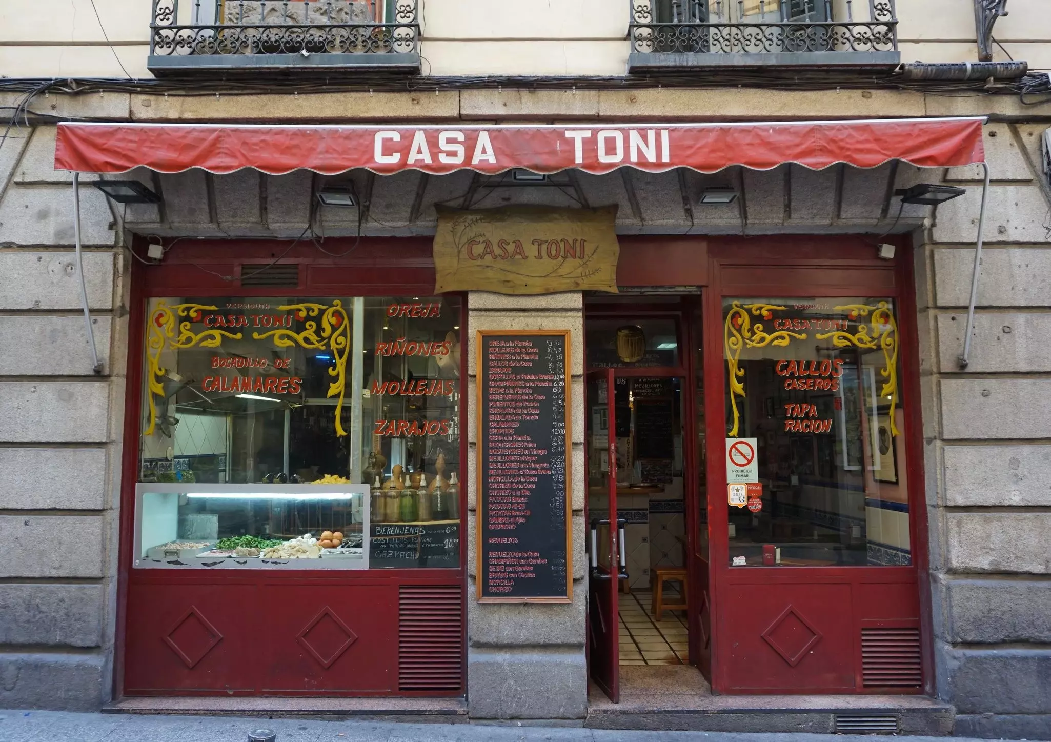 Front of a small tapas restaurant with the name "Casa Toni" on its red awning