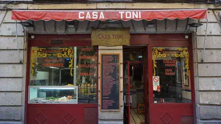 Front of a small tapas restaurant with the name "Casa Toni" on its red awning