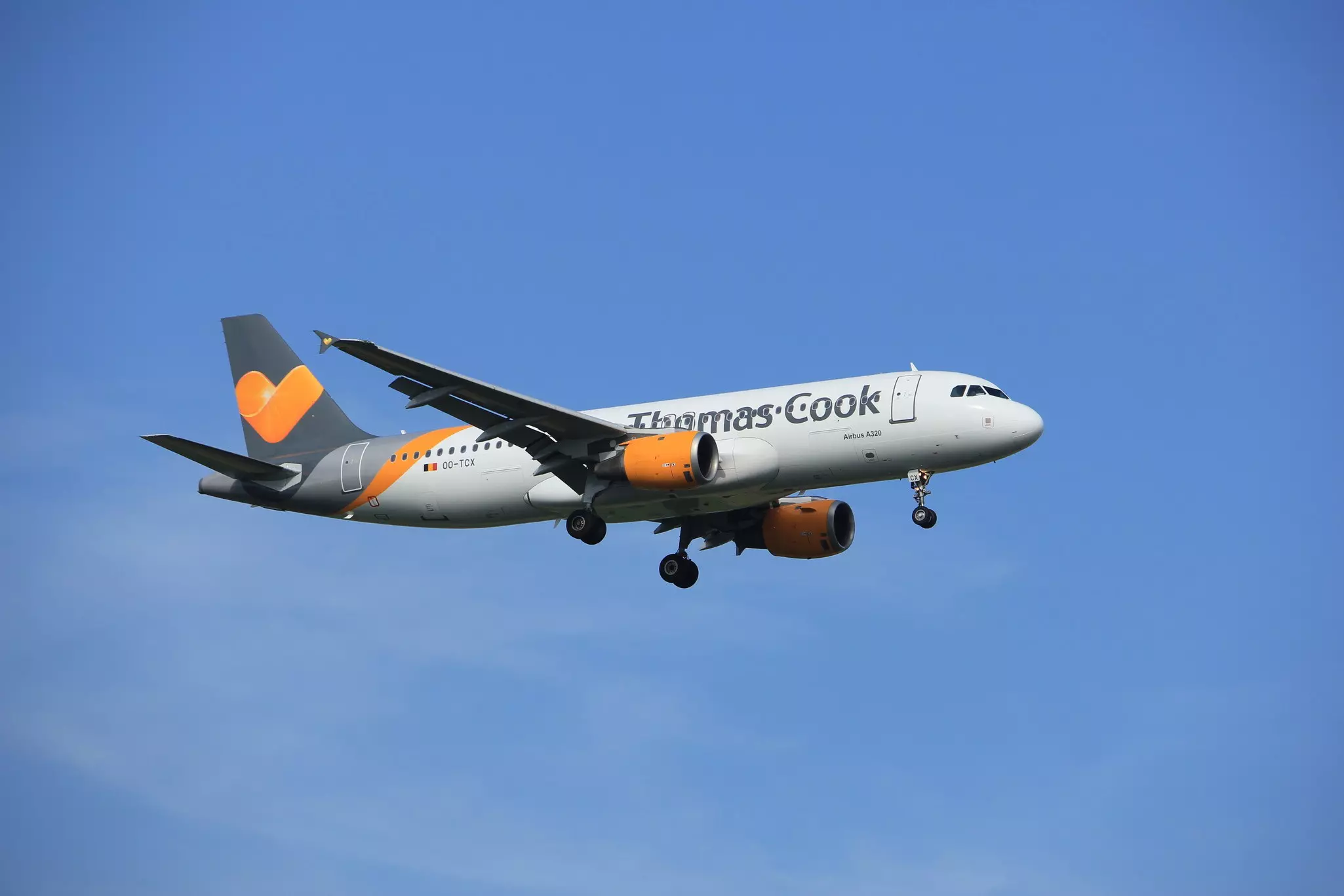 A tow of planes with orange Thomas Cook logo on the back are shown in a row.