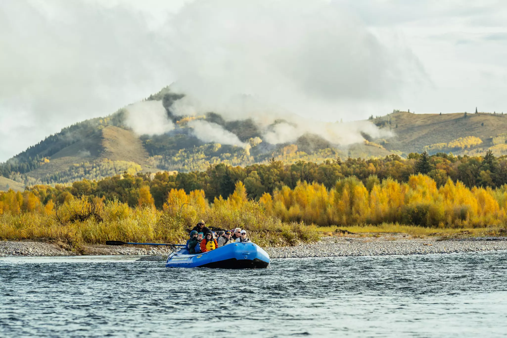 A group of people on a raft in a river.