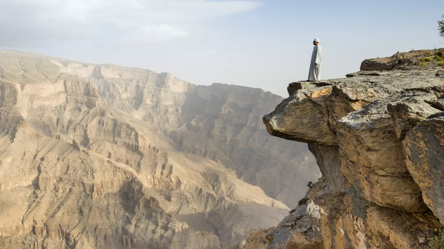 A local man fearlessly inspects Wadi Ghul,.the so-called ‘Grand Canyon of Arabia’, from the top of Jebel Shams