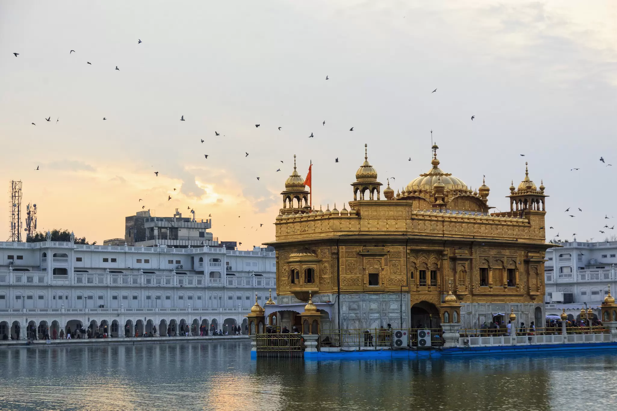 Sunset over an elaborate gold building on the water.