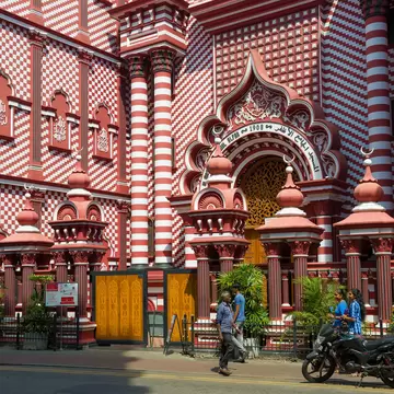 Front of a large mosque painted in red-and-white stripes
