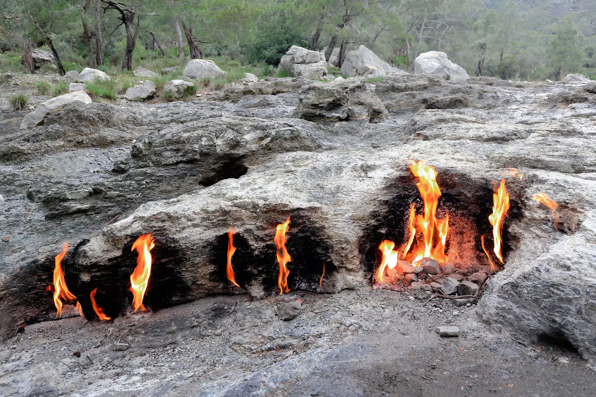 Flames burning from rock formations in the mountains in Turkey.