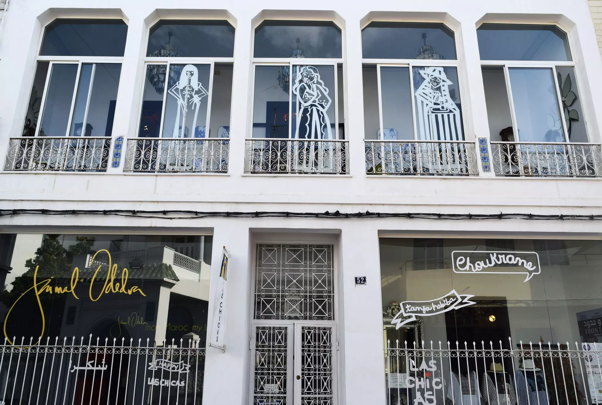 Exterior of Las Chicas, a shop with decorative white doors and white gates