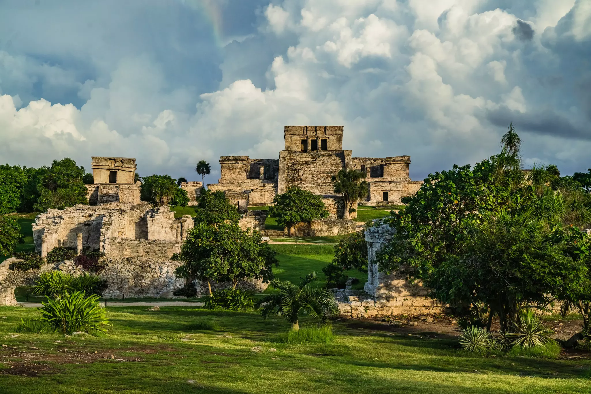 Gray storm clouds gather above the ruins of an ancient stone fortress.