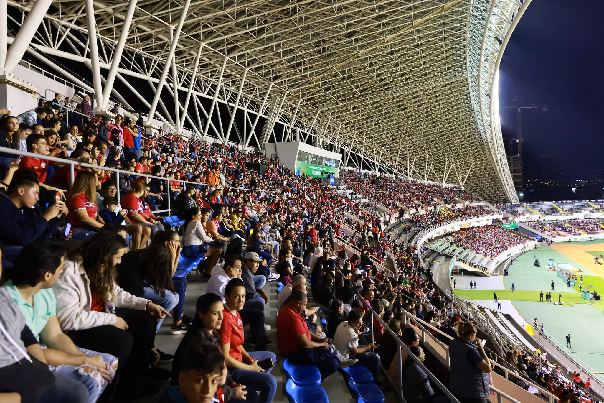 Thousands of people fill the bleachers of a huge stadium.