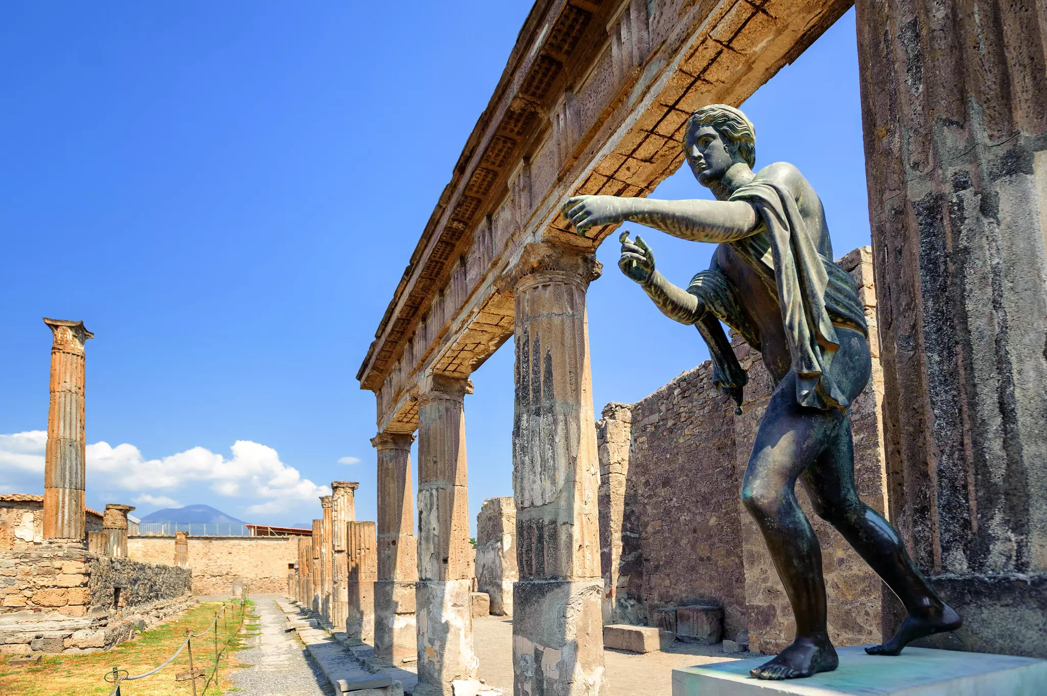 Ruins of an ancient temple with a bronze Apollo statue.