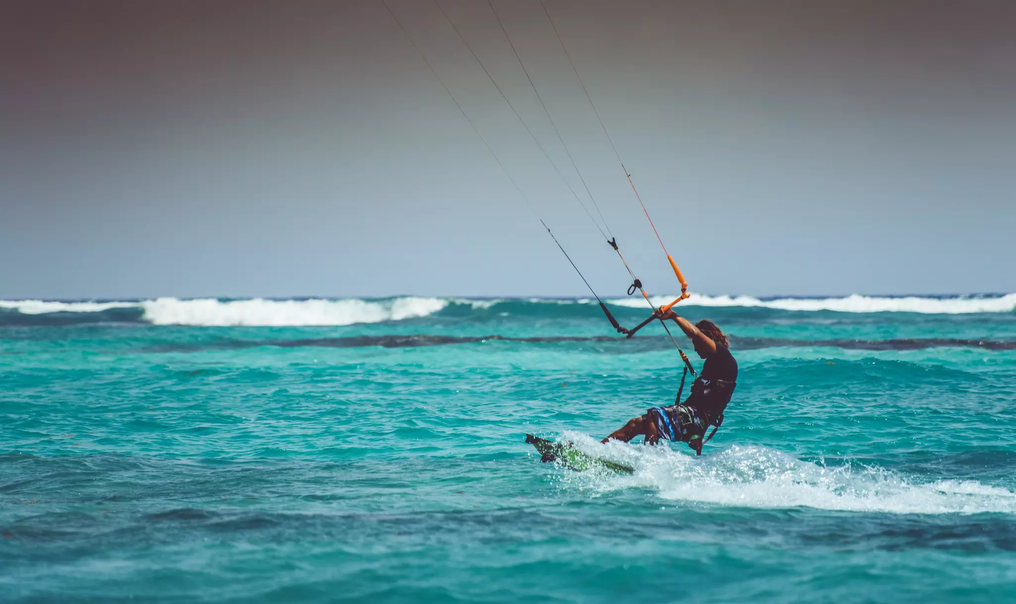 Man practicing kitesurfing on a turquoise blue water of Xpu-Há. 