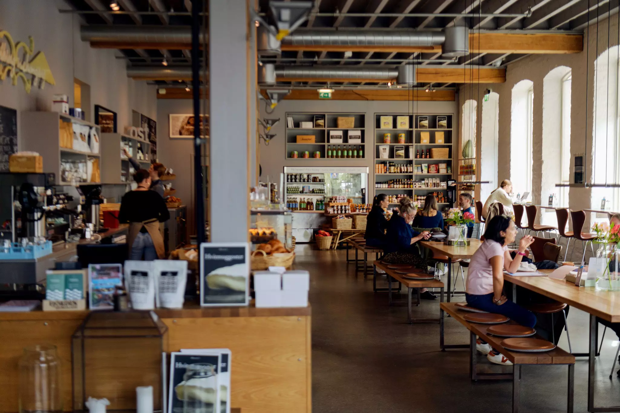People sit at a communal tables in an airy restaurant-coffee shop in the city of Stavanger, Norway.
