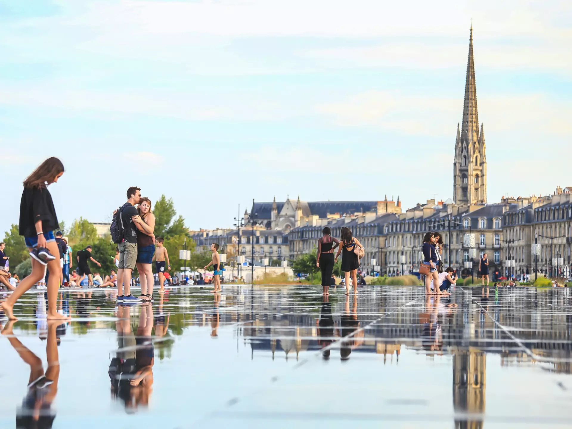 People walking barefoot through Bordeaux's Miroir d'Eau. Eo naya/Shutterstock