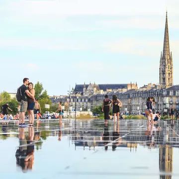 People walking barefoot through Bordeaux's Miroir d'Eau. Eo naya/Shutterstock