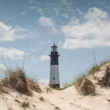 The Tybee Island lighthouse in Georgia emerges from behind sand dunes.