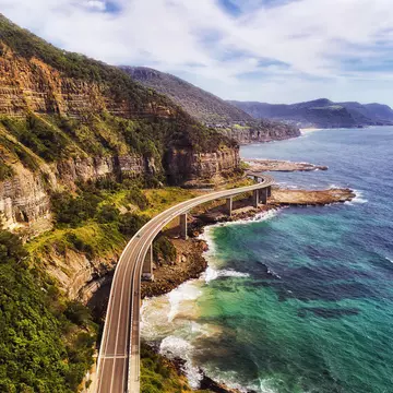 Aerial view of the Sea Cliff Bridge near steep sandstone cliffs on the Grand Pacific Drive, New South Wales, Australia