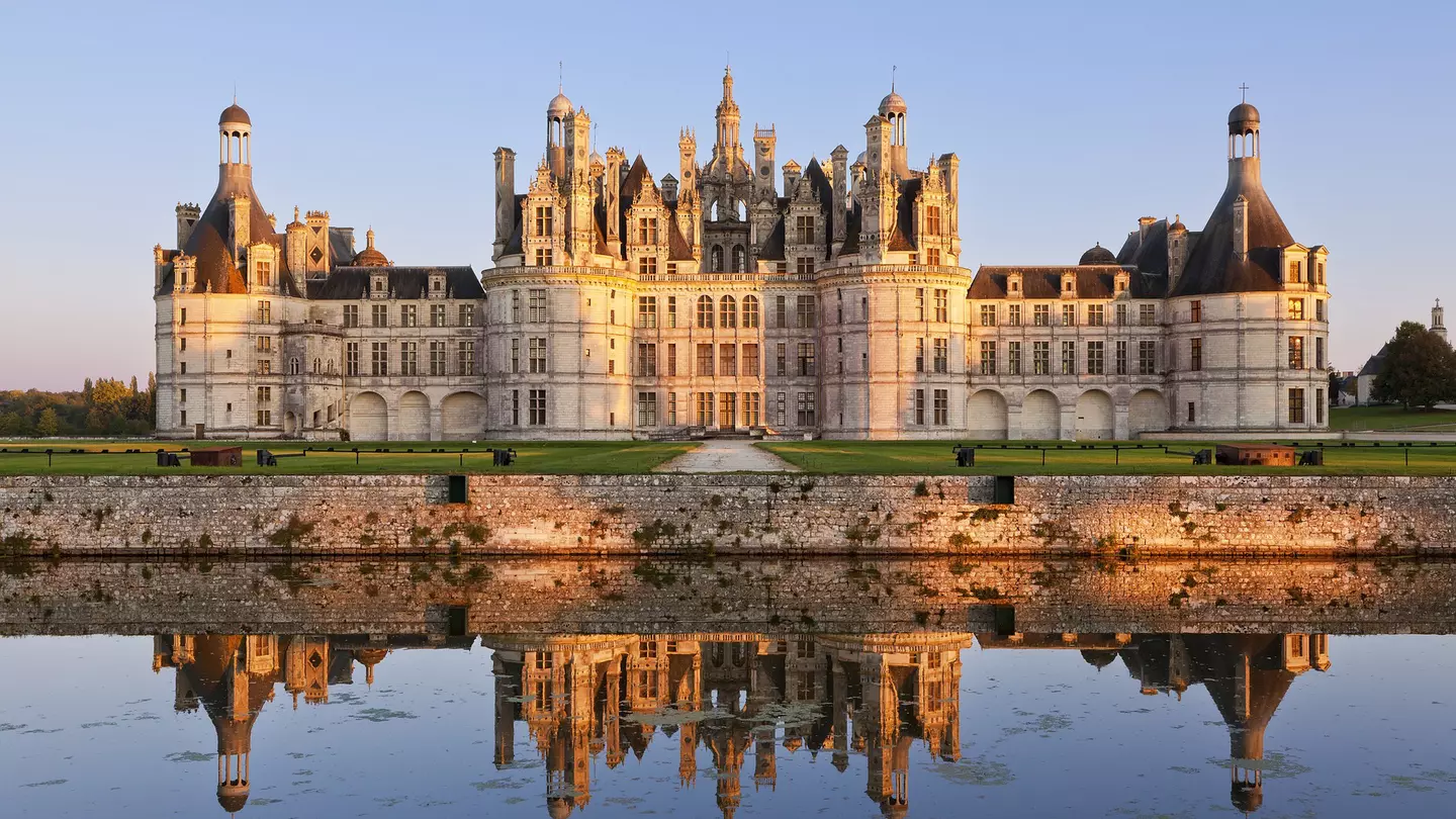 The ornate exterior of the Château de Chambord with its reflection in the lake at the front of the building