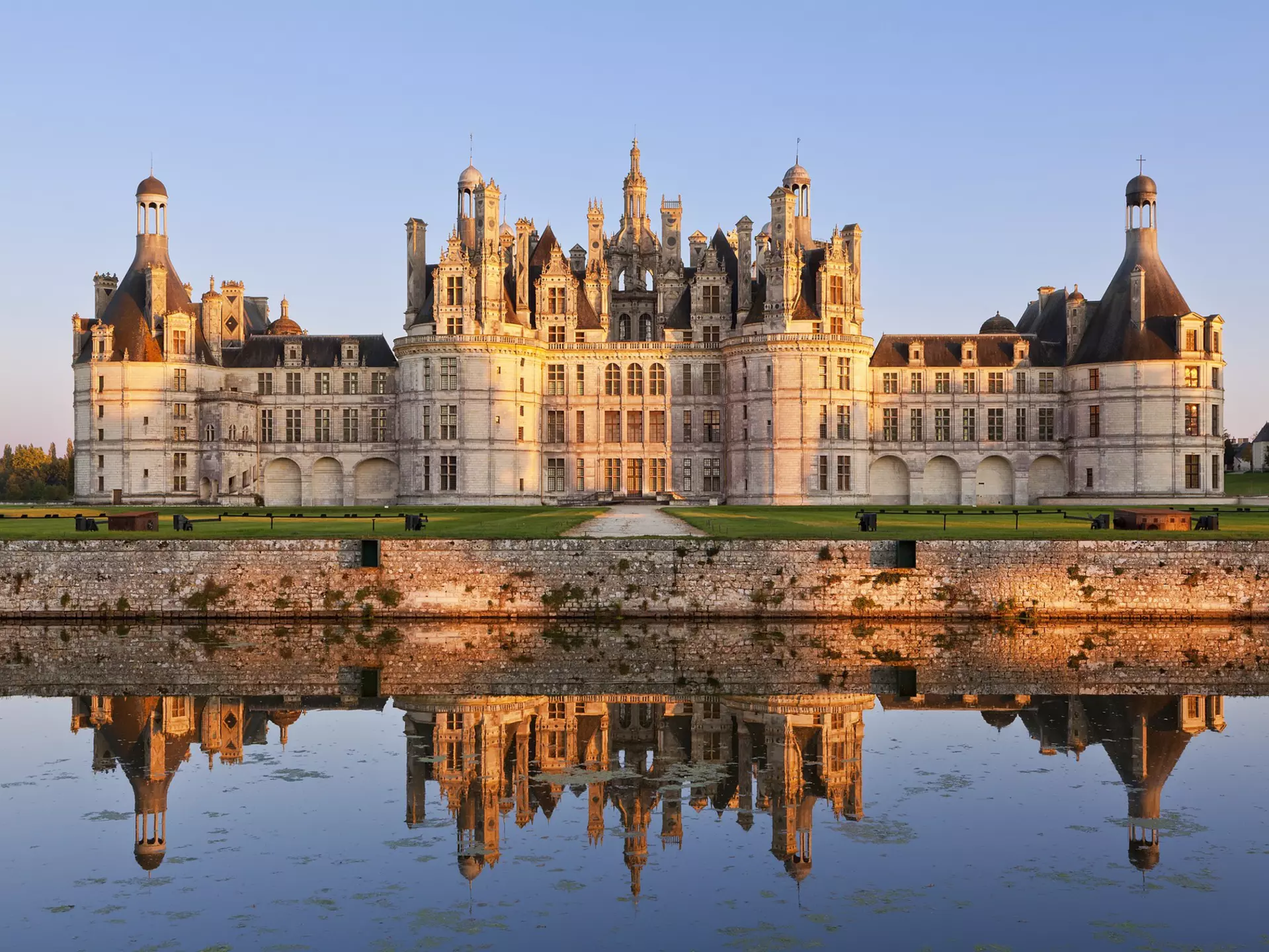 The ornate exterior of the Château de Chambord with its reflection in the lake at the front of the building