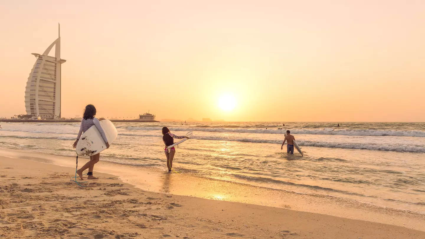 Surfers on the beach near Burj Al Arab, Dubai, United Arab Emirates