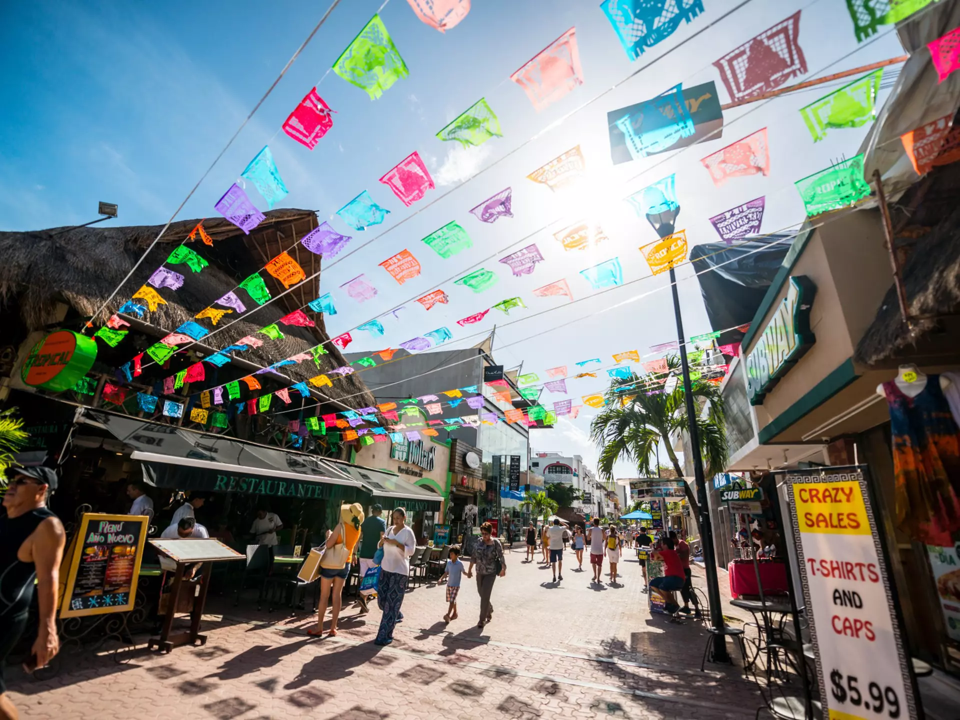Tourists exploring famous shopping street in Playa Del Carmen - 5th Avenue, Mexico