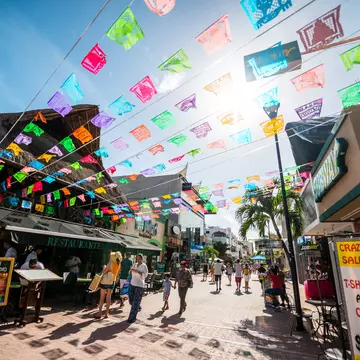 Tourists exploring famous shopping street in Playa Del Carmen - 5th Avenue, Mexico