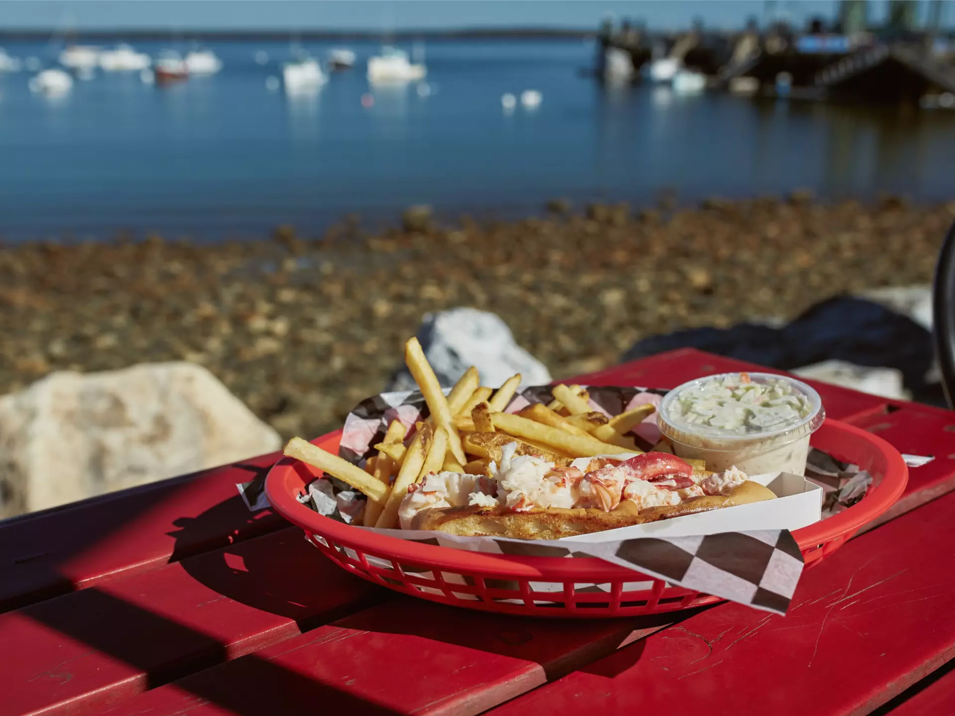 Lobster roll and french fries on a waterfront harbor in Maine. jenlo8/Shutterstock