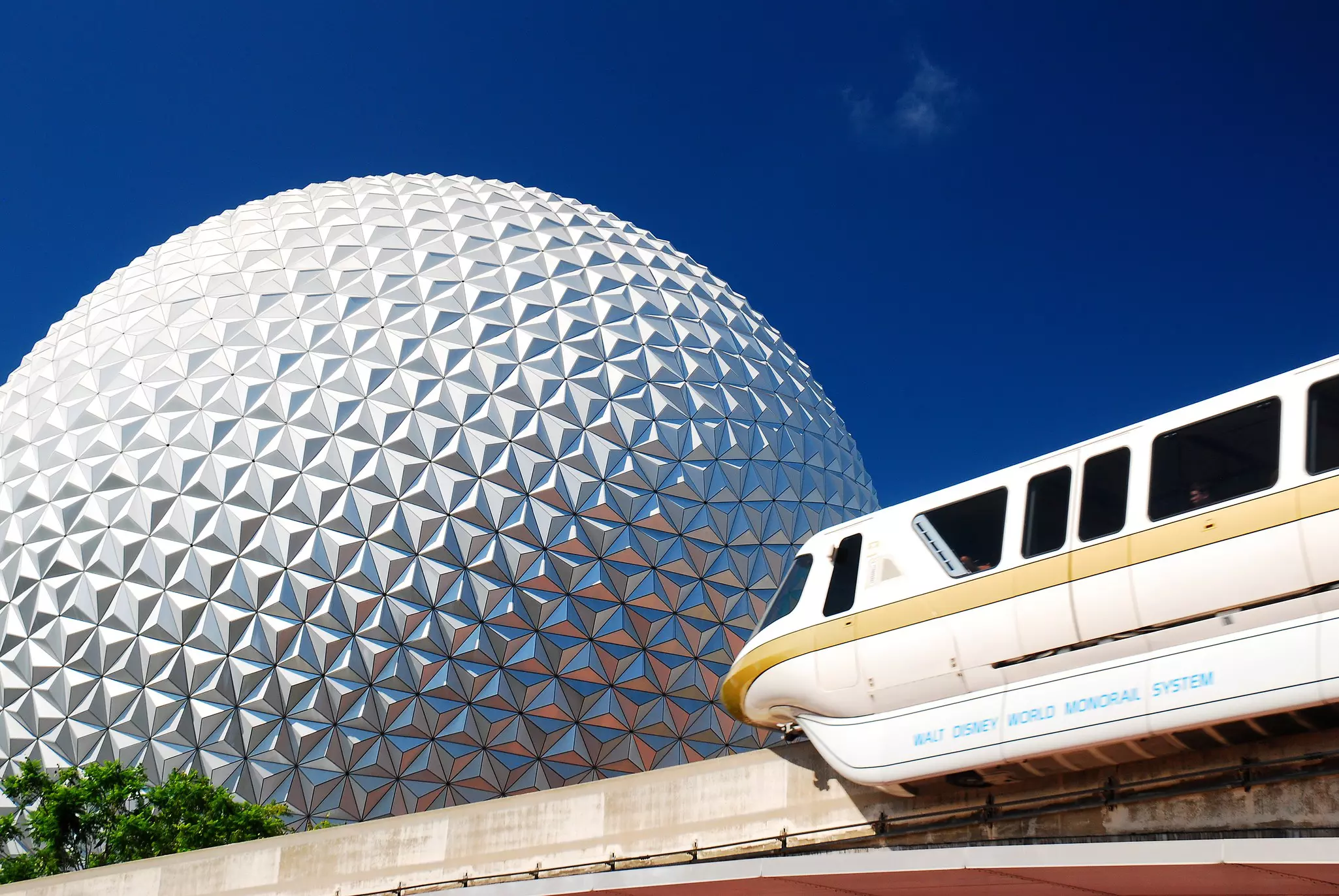 An elevated monorail passes by a giant geodesic dome at Walk Disney World, Florida.