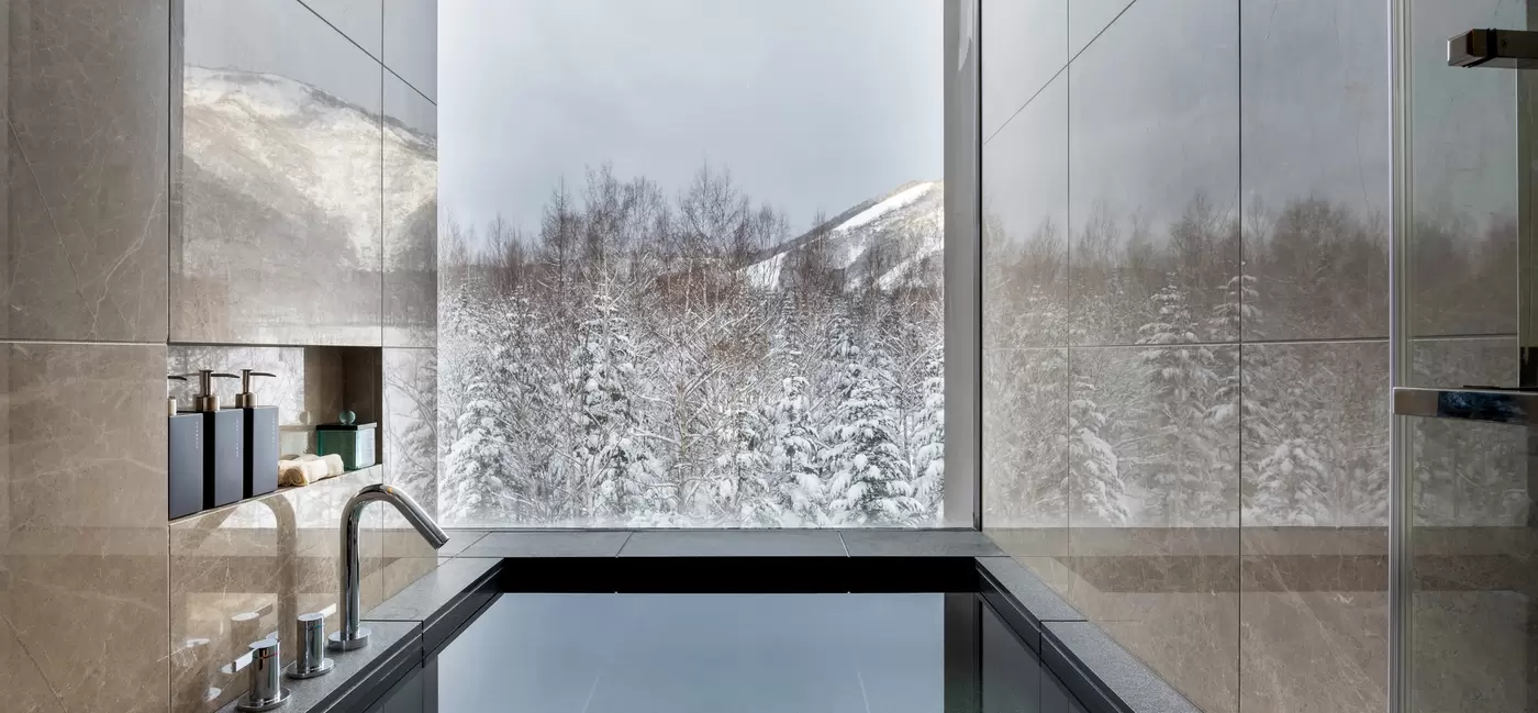 A square bathtub beside a large window: Higashiyama Niseko Village, a Ritz-Carlton Reserve, Japan