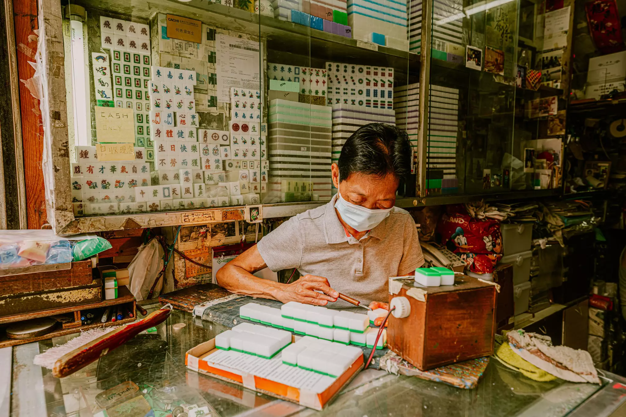 Kam Fat Mahjong, Ho Sau-mei at work on mahjong tiles in her shop in Hong Kong. 