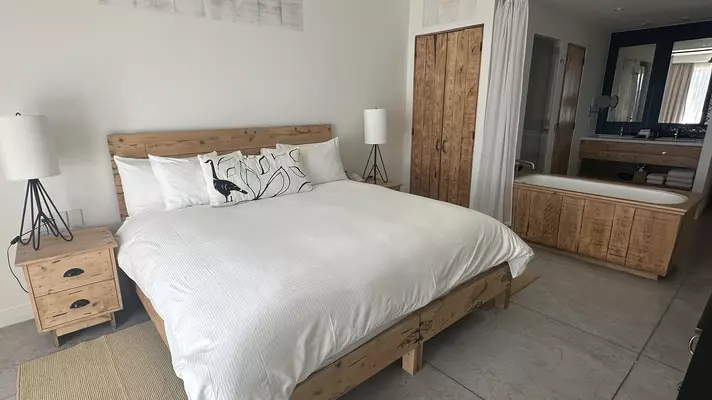 Destination Editor Melissa Yeager on rooftop of hotel at sunset. Boats and the ocean are in the background.