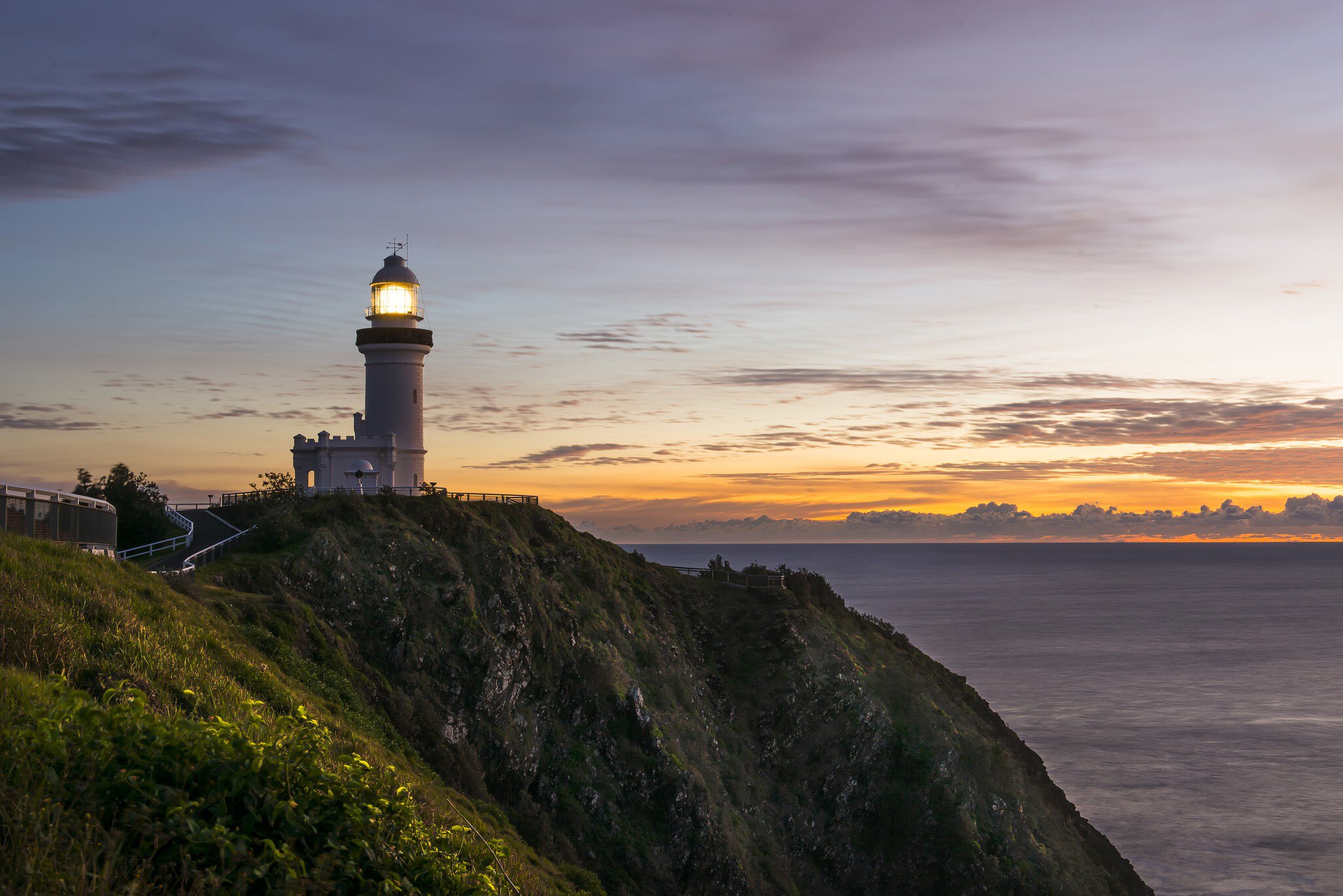 View of lighthouse on cliff at dusk, Cape Byron.
Byron Bay, Cape Byron, Clouds, beacon, cliff, dawn, daybreak, light, lighthouse, long exposure, lookout, ocean, rocks, sea, sunrise