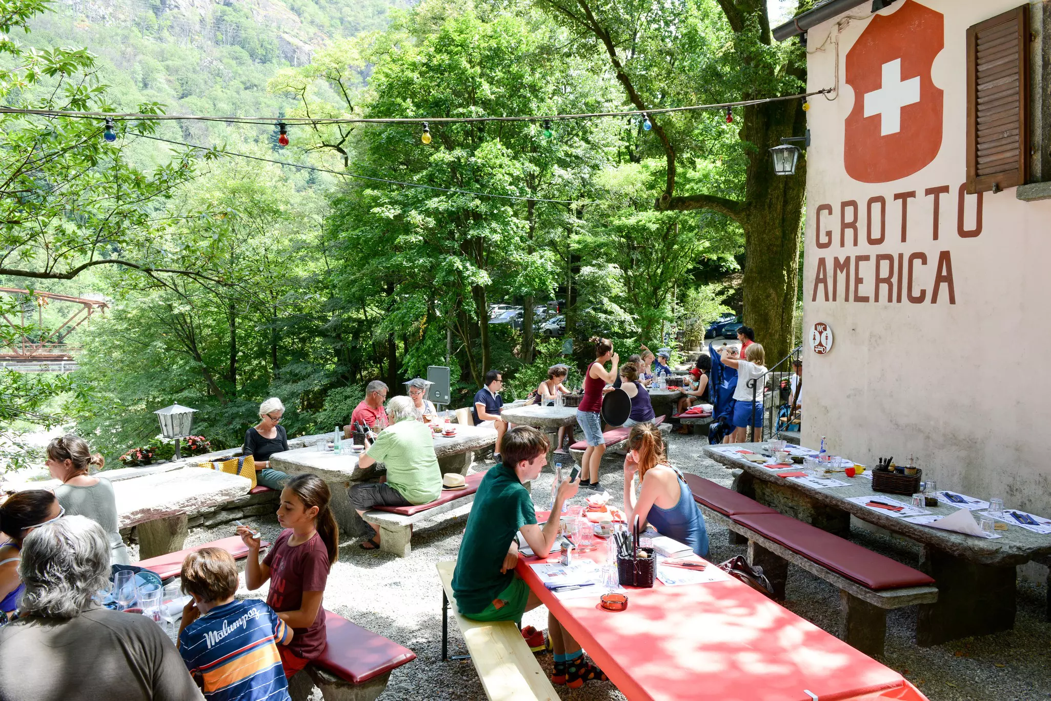 Diners in the garden of a small restaurant on the edge of woodland