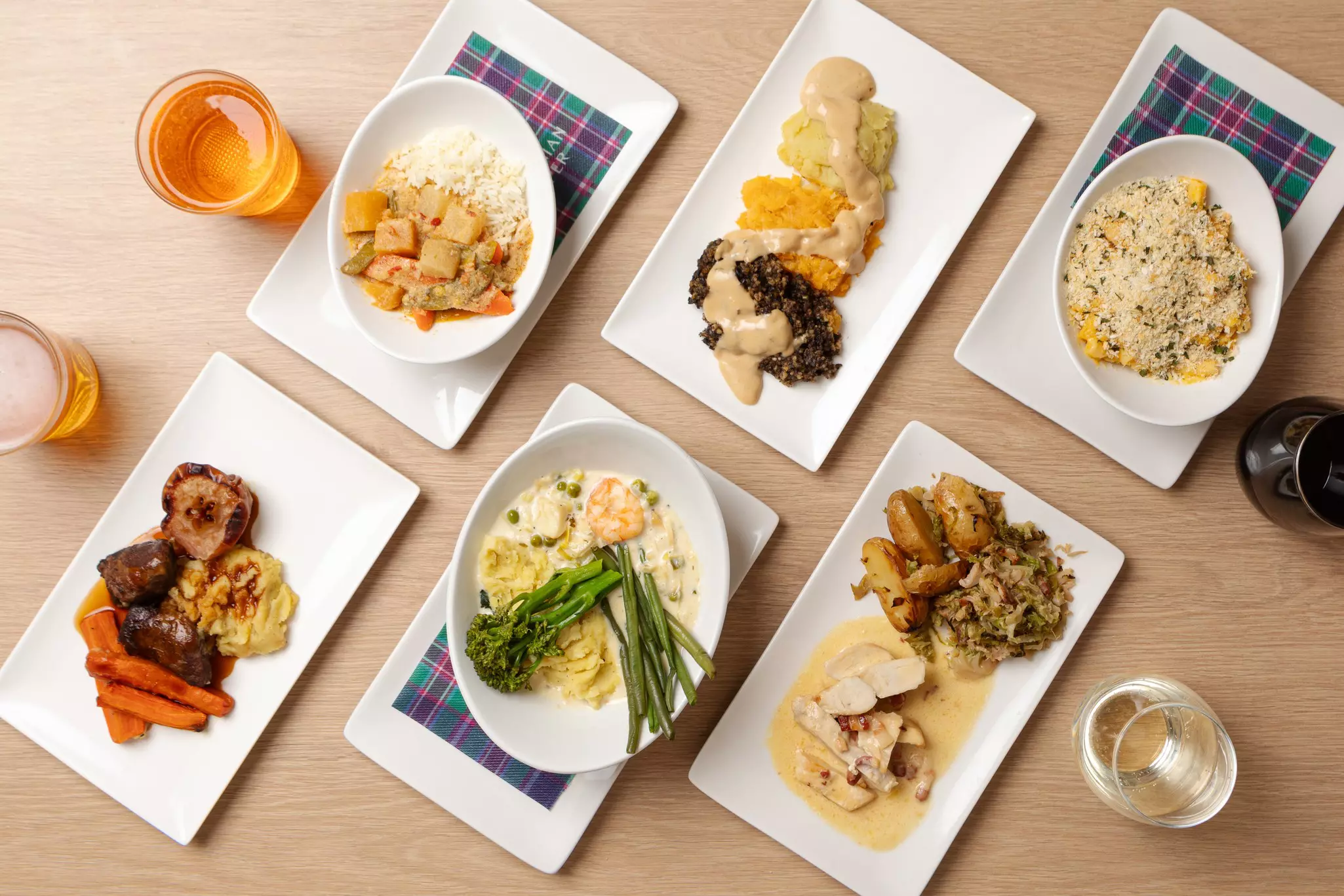 A spread of six plates with various meals, and drinks