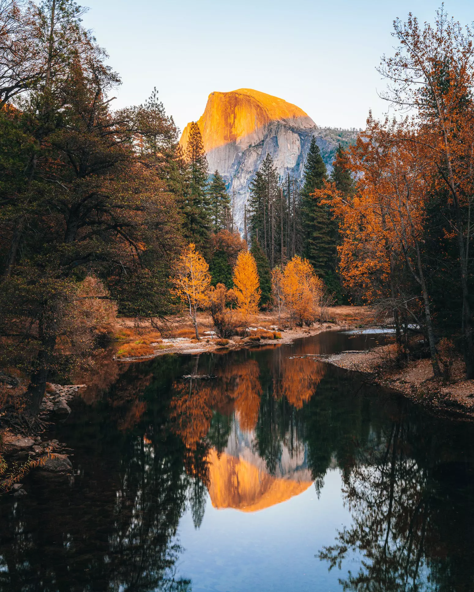 Yosemite's Half Dome reflected in water during autumn.