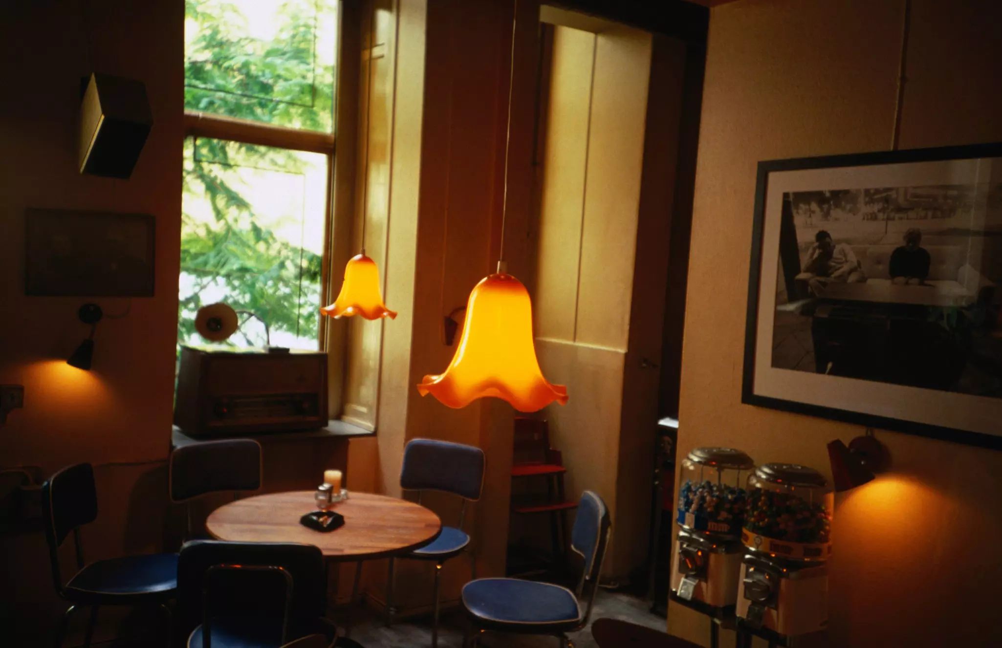 A small round table surrounded by chairs in a cafe with soft lighting in Copenhagen, Denmark